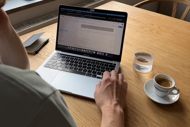 Mensch sitz am Laptop mit Kaffee